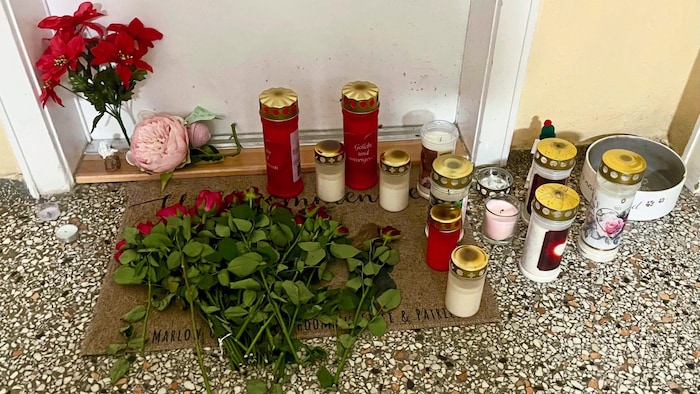 Grabkerzen und Blumen vor der Wohnungstüre des Opfers