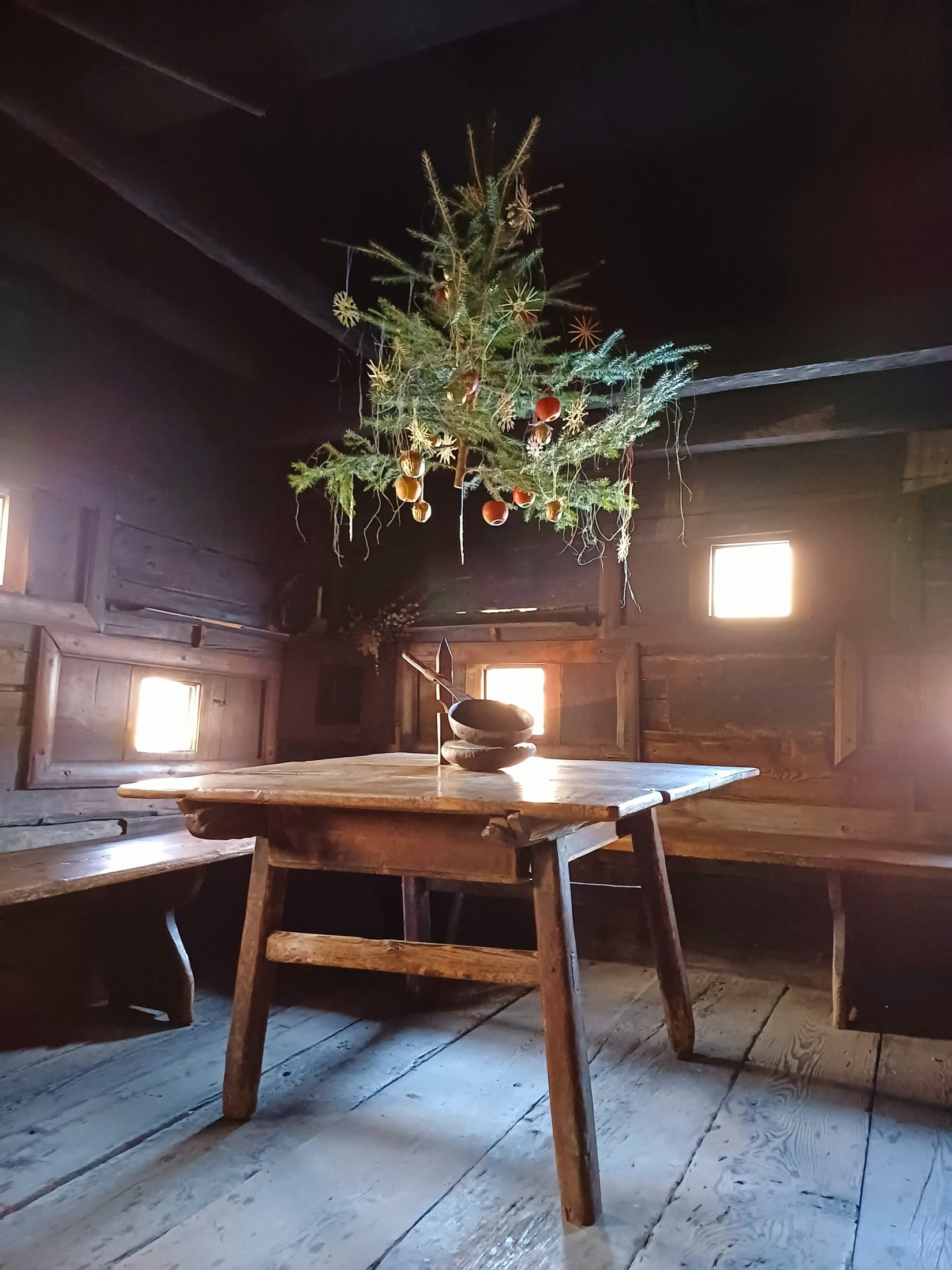 Ein Christbaum hängt von der Decke ober dem Kuchltisch.