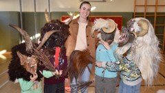 Wer sich traut, setzt eine Maske auf: Direktorin Pertl umringt von zotteligen Gestalten