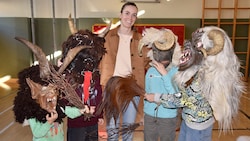 Wer sich traut, setzt eine Maske auf: Direktorin Pertl umringt von zotteligen Gestalten