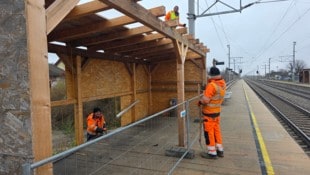 Das provisorische wetterschützende Häuschen wird abgebaut, und die Fahrgäste müssen im Regen auf ...