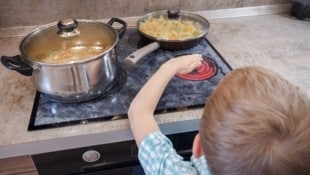 Herdschutzgitter und Topfdeckel verhindern, dass kleine Hände an heiße Flächen gelangen.