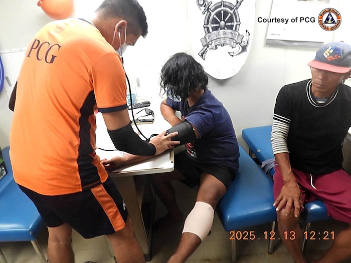 Einer der verletzten Fischer wird von medizinischem Personal untersucht und verarztet.