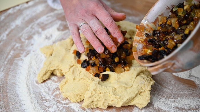 Die Zutaten mit Mehl, Eier, Trockenfrüchten; den Teig gut durchkneten, anschließend backen; ...
