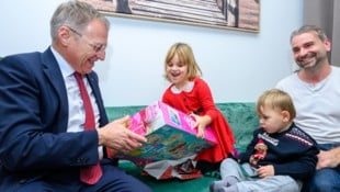 Landeshauptmann Thomas Stelzer unterstützt die fünfjährige Emma beim Auspacken. Dabei kommt ein ...