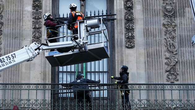 Arbeiter beim Anbringen eines Fensters nach dem Diebstahl im Kunstmuseum Louvre in Paris ...