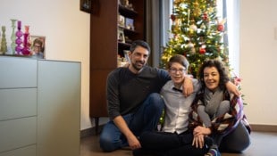 Raffael mit Mama und Papa vor dem Weihnachtsbaum.