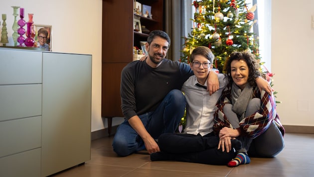 Raffael mit Mama und Papa vor dem Weihnachtsbaum.