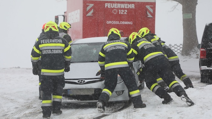 Die Feuerwehrkräfte bergen einen der kollidierten Pkw.