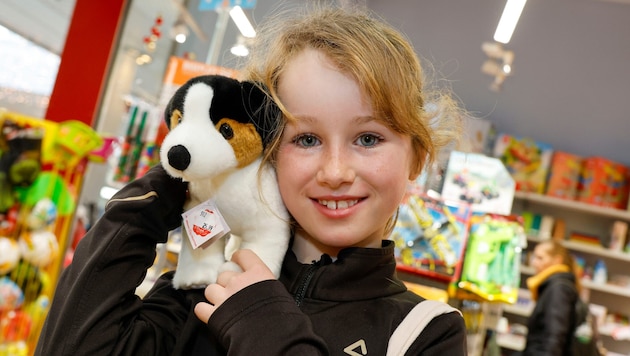 Frida hat sich mit Gutscheinen einen Plüschhund gekauft.