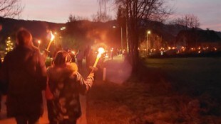 Kinder wandern mit Fackeln zum Fischerpark in Döbriach.