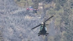 Mehrere Hubschrauber der Polizei und des Bundesheeres flogen Löschwasser auf den Berg, vom Boden ...
