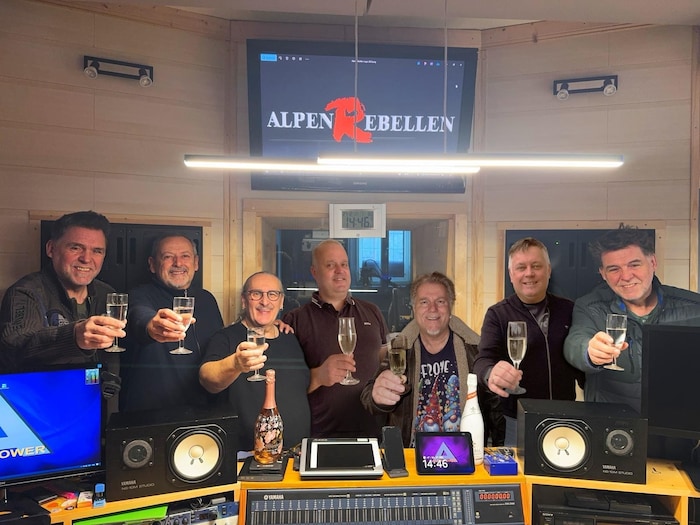 Die AlpenRebellen wünschen ein „Prosit 2026“ aus ihrem Tonstudio.