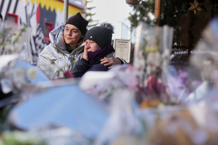 Vor dem ausgebrannten Gebäude legen Menschen still Erinnerungen nieder. Die Trauer ist greifbar.