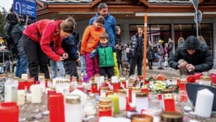 Menschen legen Kerzen und Blumen nahe der Unglücksstelle ab.