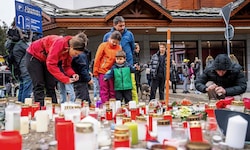 Menschen legen Kerzen und Blumen nahe der Unglücksstelle ab.