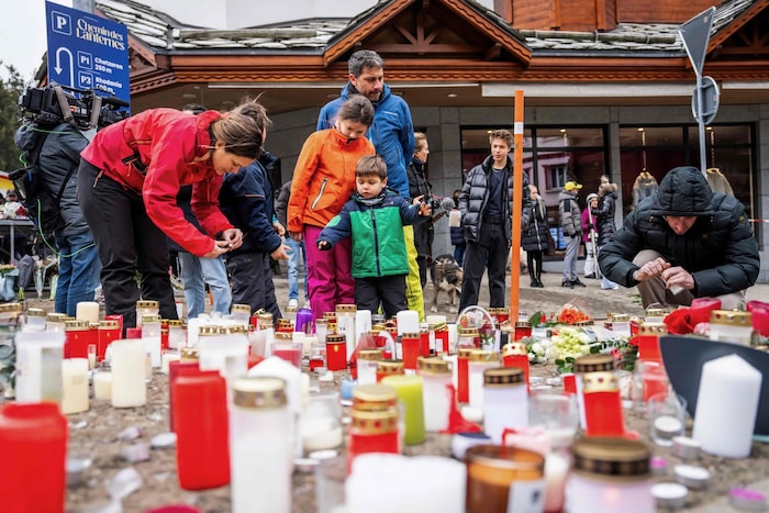 Viele Menschen stellen Kerzen auf.