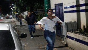 Diese Passantinnen und Passanten bringen sich gerade vor den Explosionen in Venezuelas ...