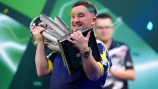 Luke Littler jubelt mit der WM-Trophäe.