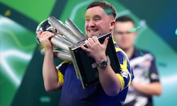 Luke Littler jubelt mit der WM-Trophäe.