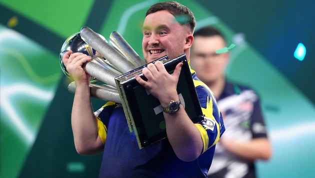 Luke Littler jubelt mit der WM-Trophäe.
