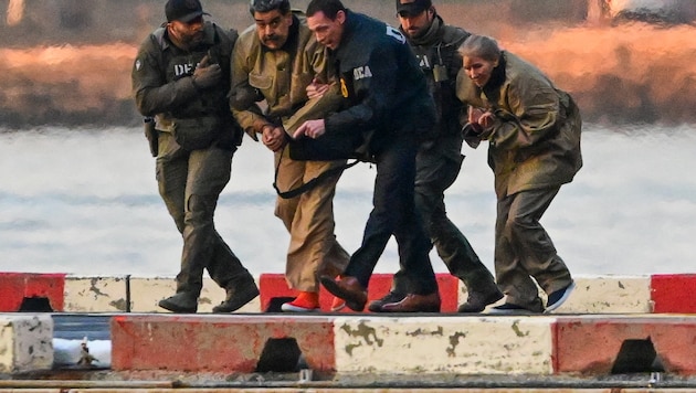 Maduro und seine Ehefrau werden von Drogenbeamten abgeführt.