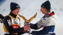 Daniel Tschofenig (rechts) übergibt den Goldadler an Domen Prevc.