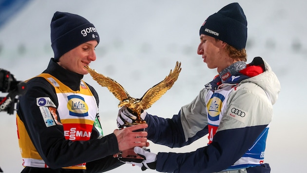 Daniel Tschofenig (rechts) übergibt den Goldadler an Domen Prevc.