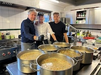 Rudolf Tomaschitz-Türk mit seinen Söhnen Tobias und Marco vor den gefüllten Ritschert-Kesseln. ...