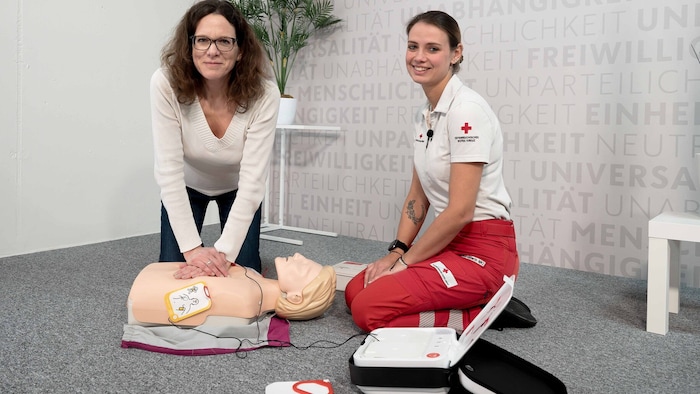 Georgia Praska (re.) erklärt, wie man den Defibrillator richtig verwendet.