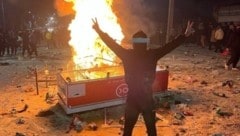 Ein Demonstrant steht in Abdanan auf dem bei den Protesten verstreuten Reis.