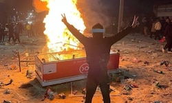 Ein Demonstrant steht in Abdanan auf dem bei den Protesten verstreuten Reis.
