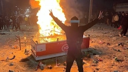 Ein Demonstrant steht in Abdanan auf dem bei den Protesten verstreuten Reis.