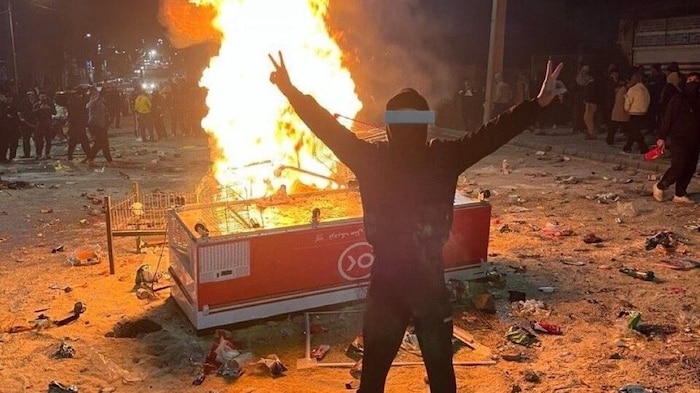 Ein Demonstrant steht in Abdanan auf dem bei den Protesten verstreuten Reis.