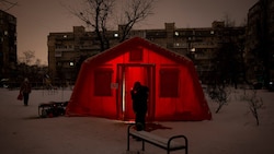 Ein Mann steht vor einem geheizten Notfallzelt in Kiew. Ständige Luftangriffe auf das ...