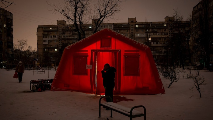 Ein Mann steht vor einem geheizten Notfallzelt in Kiew. Ständige Luftangriffe auf das ...