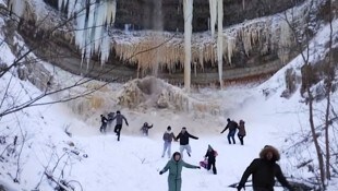 Die Schaulustigen rannten in Panik davon, als sich die Eisblöcke vom Wasserfall lösten.