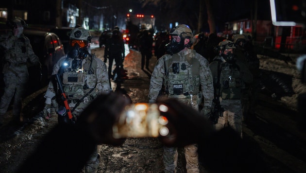 Ein Demonstrant in Minneapolis richtet während eines Protests sein Handy auf Beamte der ...