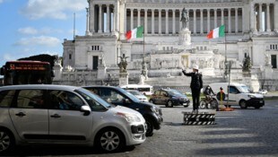 Eine Polizistin regelt den Verkehr am Piazza Venezia in Rom.
