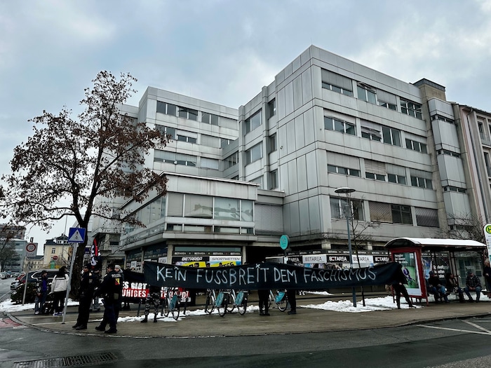 Demonstranten stehen vor dem Messezentrum.
