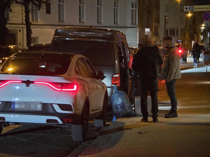 Investigators in front of the deceased's apartment