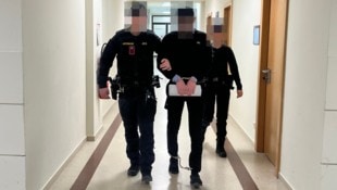 Abu Bakar D. wird mit Fuß- und Handfesseln vorgeführt.