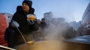 Eine freiwillige Helferin verteilt warme Mahlzeiten nach einem Stromausfall in Kiew ...