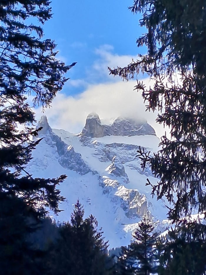 Zwischen den Wolken ragt das Wahrzeichen, des Montafons, die Drei Türme, heraus.