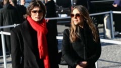 Liz Hurley und Sohn Damian, elegant mit einem Schal in Valentino‑Rot, erweisen Valentino ...