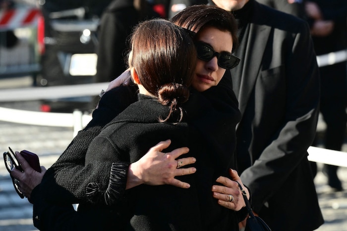 Anne Hathaway nimmt einen anderen Trauergast bei ihrer Ankunft in die Arme.