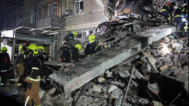 Einsatzkräfte suchen in den Trümmern eines Wohnhauses in Odessa nach Verschütteten.
