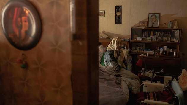 Eine ältere Frau muss nach russischen Angriffen auf die Energieinfrastruktur in ihrer Wohnung ...