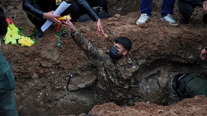 Kurdische Soldaten heben in Qamishli Gräber für Kameradinnen und Kameraden aus.