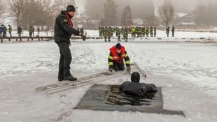 Mit Leitern tasteten sich Feuerwehrleute bis an den im Wasser eingebrochenen Mann heran.